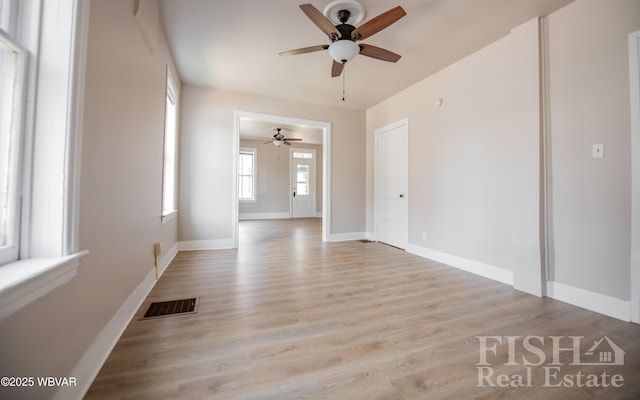 spare room with visible vents, a ceiling fan, baseboards, and wood finished floors