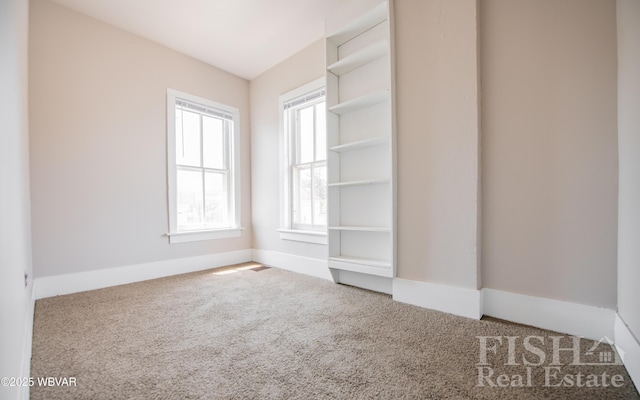 carpeted spare room featuring baseboards