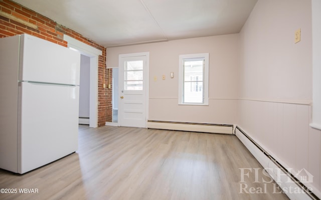 interior space featuring brick wall, wood finished floors, and a baseboard radiator
