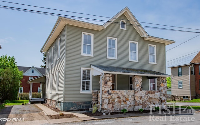 view of front of home with covered porch and stone siding