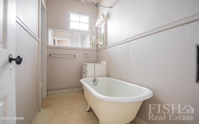 bathroom featuring a freestanding bath, tile walls, and wainscoting