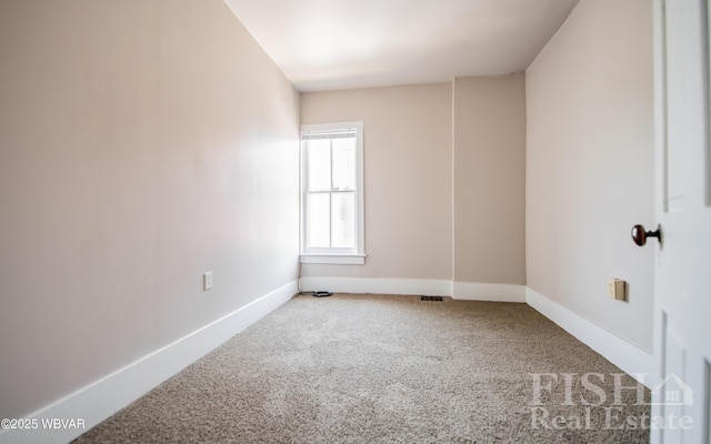 carpeted spare room featuring baseboards and visible vents