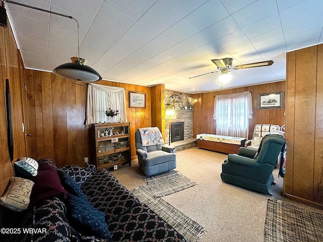 2155 Slacks Run Rd, Trout Run, PA 17771 - living room featuring wood walls, ceiling fan, a stone fireplace, and carpet floors