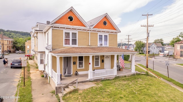 victorian house featuring covered porch and a front yard