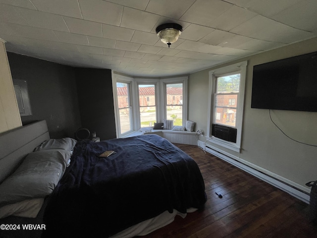 bedroom featuring dark hardwood / wood-style flooring and a baseboard heating unit