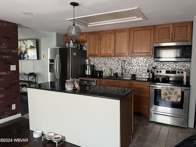 kitchen featuring appliances with stainless steel finishes, backsplash, a raised ceiling, sink, and a kitchen island