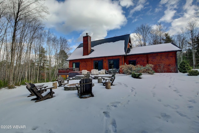 snow covered house with an outdoor fire pit