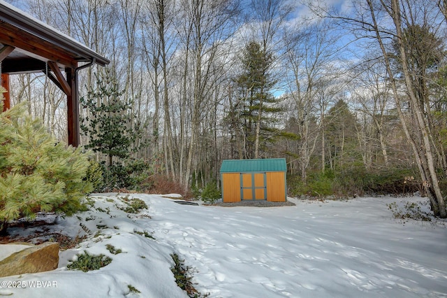 yard layered in snow featuring a storage unit