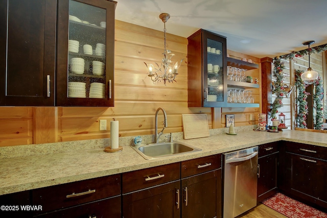 kitchen featuring hanging light fixtures, dishwasher, sink, and a chandelier