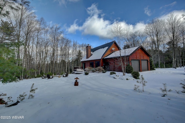 snow covered property with a garage