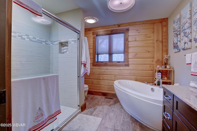 full bathroom with plus walk in shower, vanity, wooden walls, and toilet