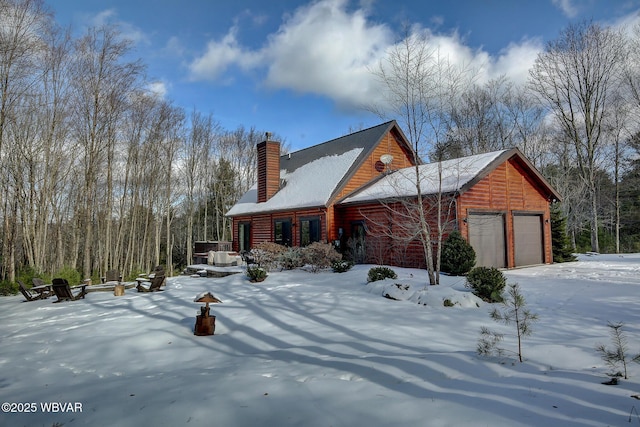 view of snow covered exterior with a garage