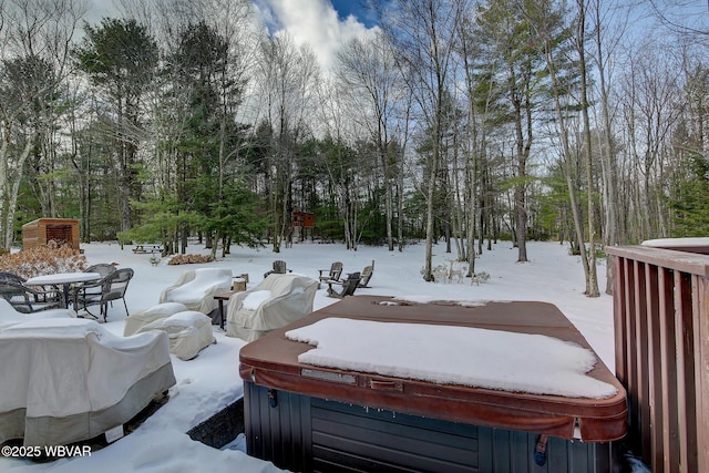 yard layered in snow with a hot tub