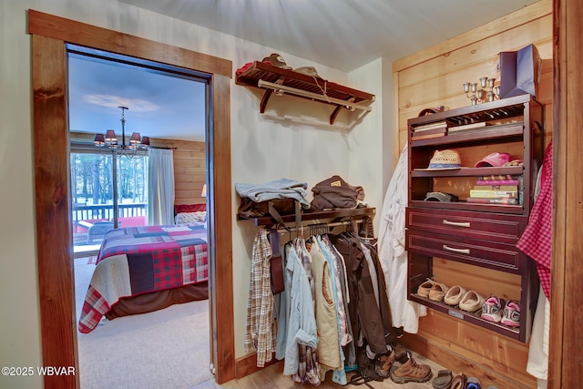 walk in closet with a notable chandelier