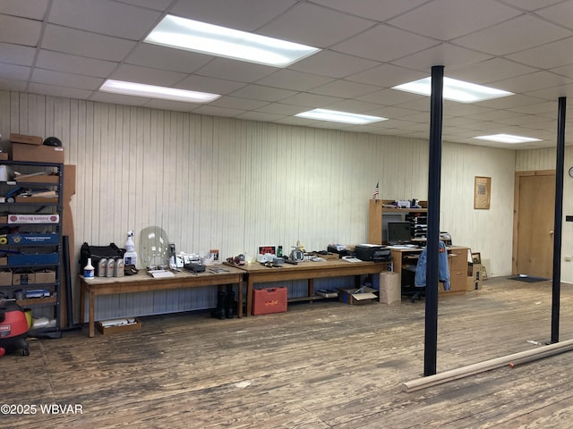 interior space featuring a drop ceiling, a workshop area, and dark hardwood / wood-style floors