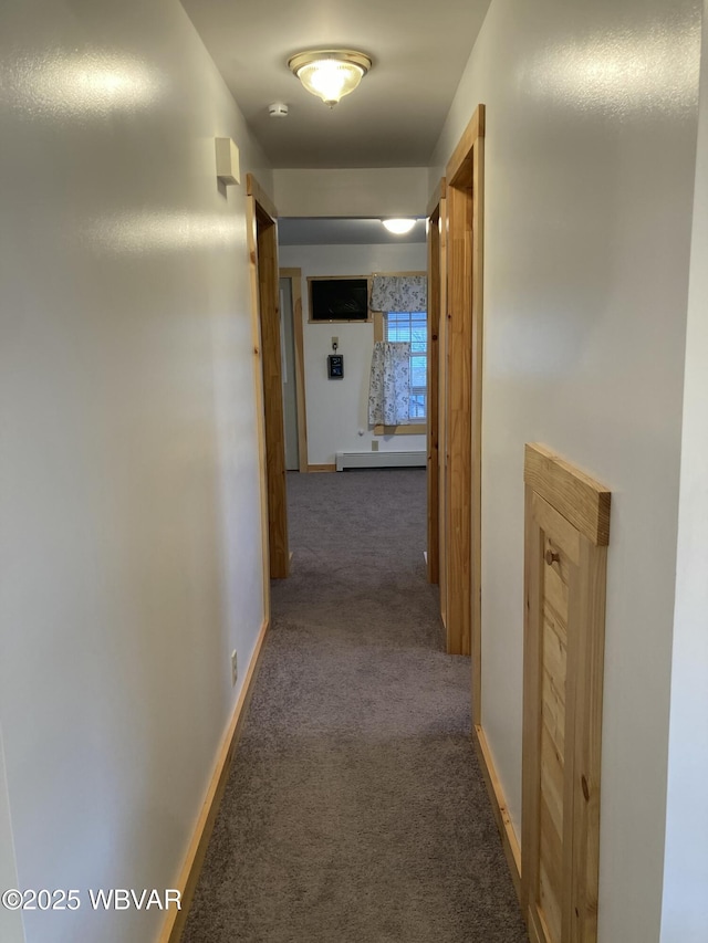 corridor featuring dark colored carpet and a baseboard heating unit