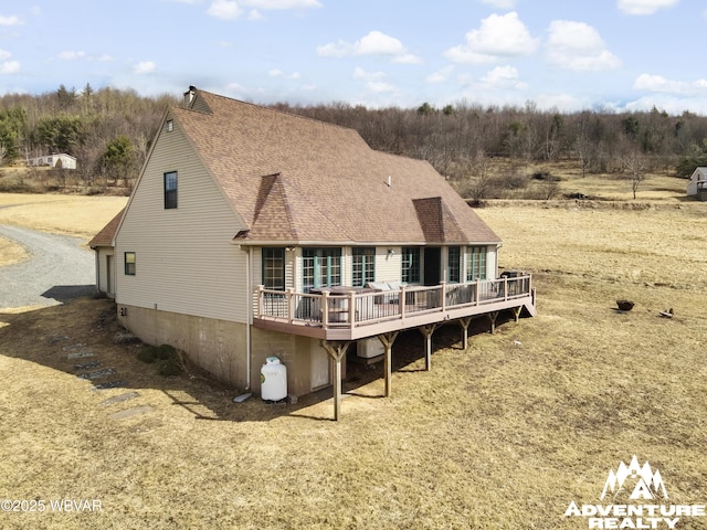 back of house with a wooden deck and a shingled roof