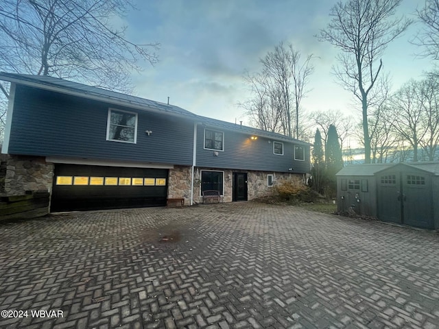 view of front of home with a storage unit and a garage