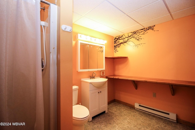 bathroom with a drop ceiling, toilet, vanity, and a baseboard radiator