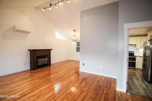 unfurnished living room featuring high vaulted ceiling, an inviting chandelier, an AC wall unit, light hardwood / wood-style flooring, and beam ceiling