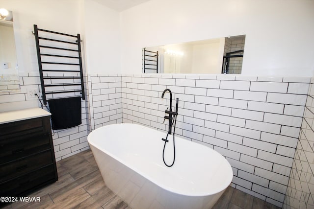 bathroom with vanity, shower with separate bathtub, and tile walls