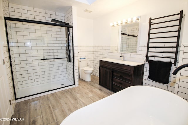 full bathroom with vanity, separate shower and tub, toilet, tile walls, and wood-type flooring