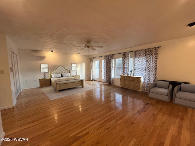 unfurnished bedroom featuring ceiling fan, a wall unit AC, and light hardwood / wood-style flooring