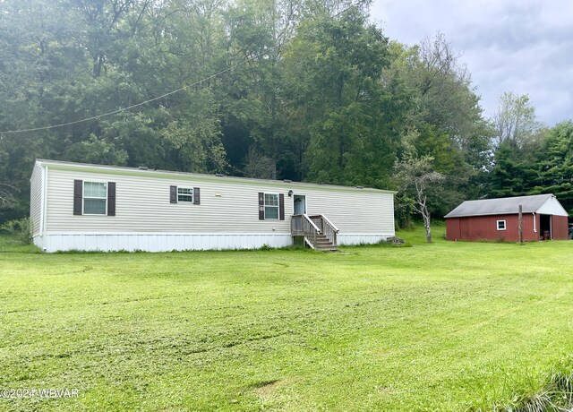 manufactured / mobile home with an outbuilding and a front yard