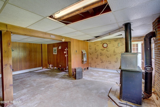 443 Derr Hill Rd, Lock Haven, PA 17745 - below grade area with a wood stove, a baseboard radiator, a drop ceiling, and wood walls