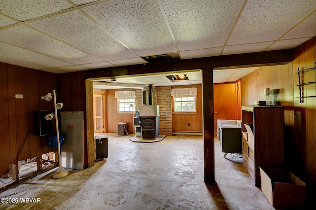 443 Derr Hill Rd, Lock Haven, PA 17745 - unfurnished living room with wood walls, a drop ceiling, a wood stove, and unfinished concrete flooring