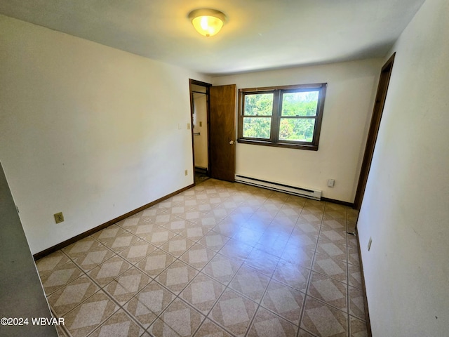 unfurnished room featuring a baseboard heating unit and baseboards