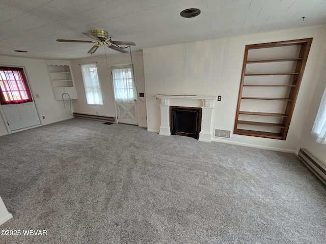 unfurnished living room with carpet, a fireplace, visible vents, and a wealth of natural light