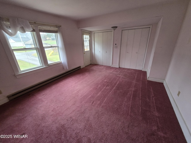 unfurnished bedroom with multiple closets, a baseboard radiator, carpet flooring, and baseboards