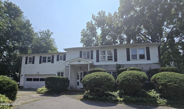 view of front facade featuring a garage, driveway, and brick siding