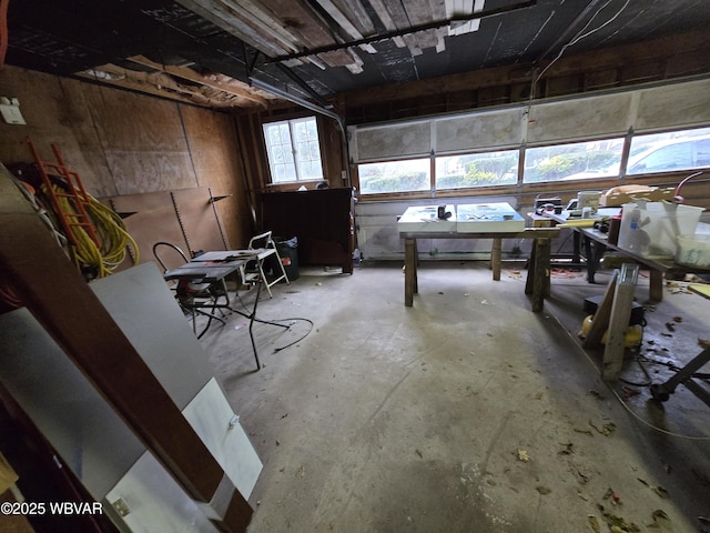 miscellaneous room with a garage and unfinished concrete floors