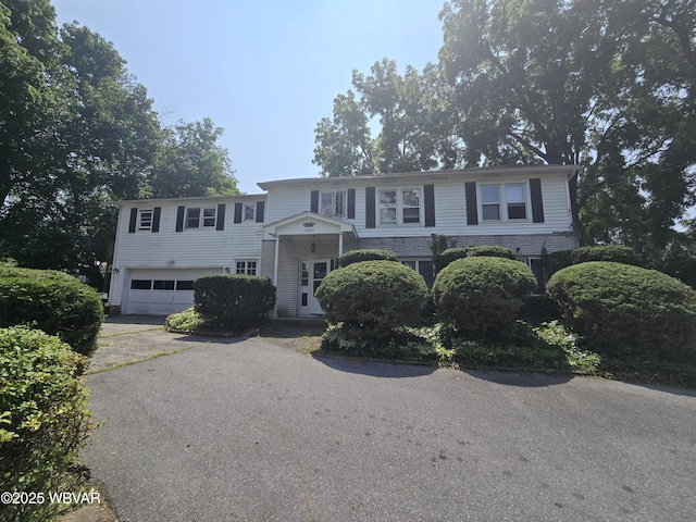 view of front of property with aphalt driveway, brick siding, and a garage