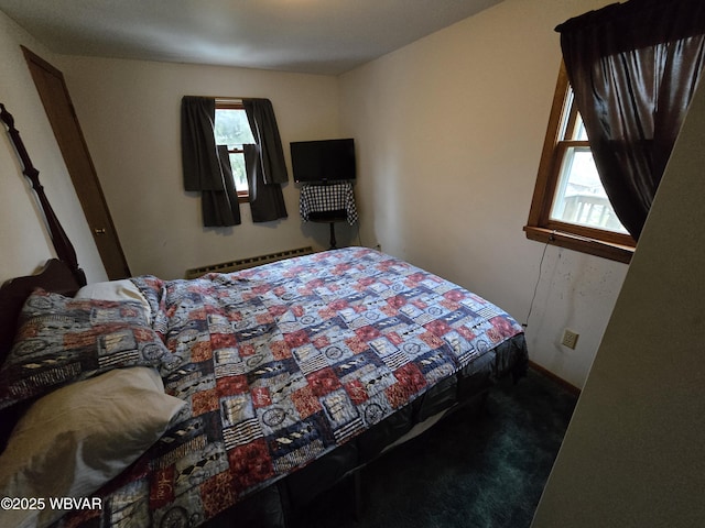 carpeted bedroom with a baseboard radiator