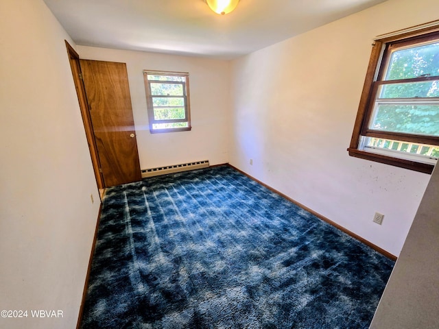 empty room with a baseboard radiator, carpet flooring, and baseboards