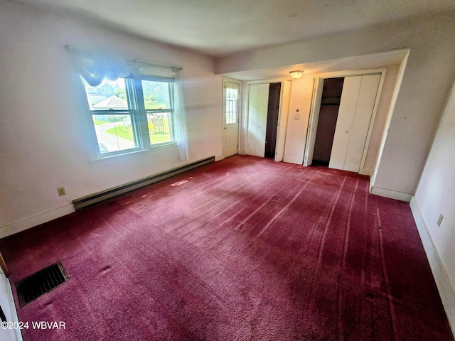 unfurnished bedroom with carpet floors, a baseboard radiator, visible vents, and multiple closets