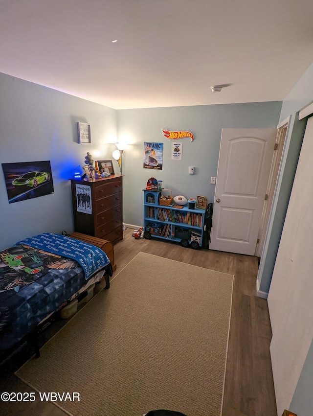 bedroom with wood finished floors and baseboards