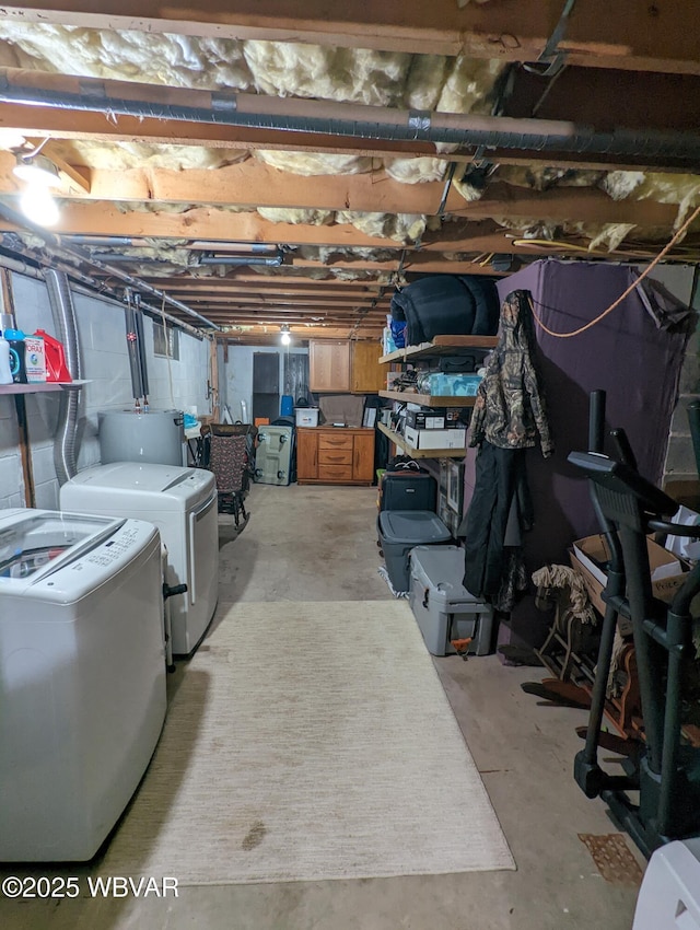 unfinished below grade area featuring water heater and separate washer and dryer