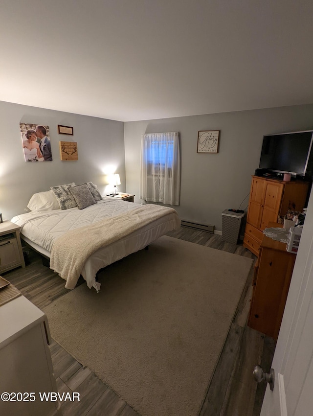 bedroom featuring dark wood finished floors and baseboard heating