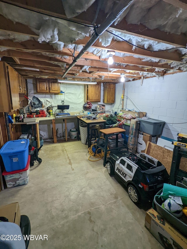 unfinished basement with a workshop area and concrete block wall