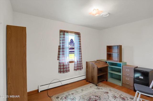 home office with a baseboard heating unit and hardwood / wood-style floors