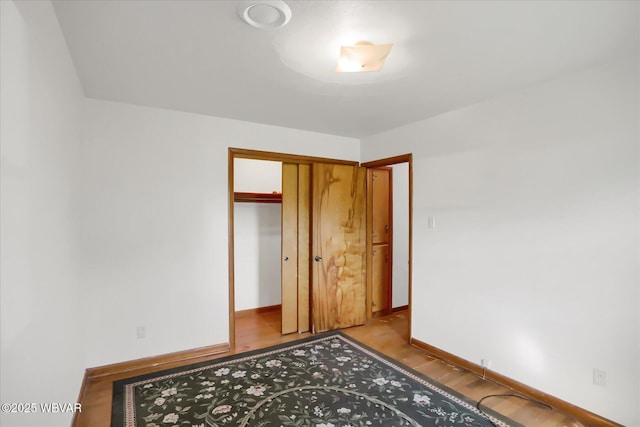 unfurnished bedroom with light wood-type flooring and a closet