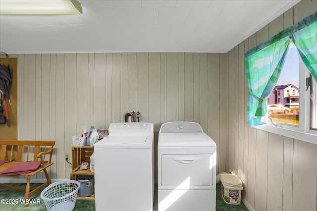 washroom featuring washing machine and clothes dryer and wooden walls