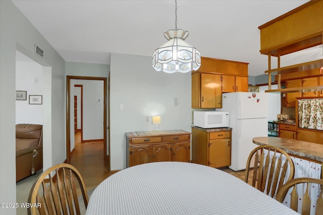 kitchen featuring white appliances and decorative light fixtures