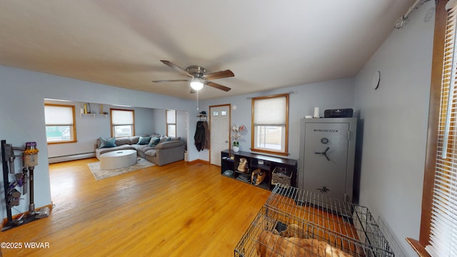 599 E Academy St, Hughesville, PA 17737 - living room with baseboards, ceiling fan, a baseboard heating unit, and wood finished floors