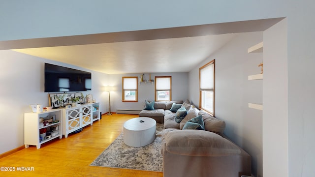 living room with light wood finished floors, baseboards, and a baseboard heating unit