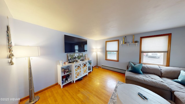 living area featuring light wood finished floors, baseboards, and baseboard heating